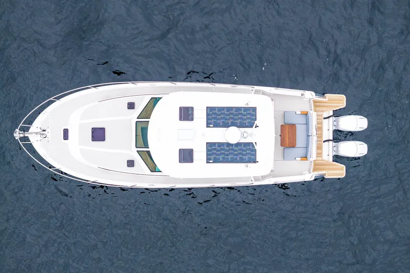 Slide: The Image of Aerial view of 2025 Back Cove 39O boat on water, showcasing sleek design and twin engines. - 10