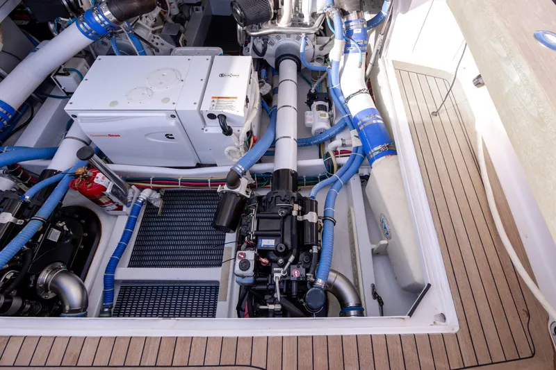 Slide: The Image of Engine room of 2015 Jarrett Bay Hardtop Express Sportfish with Cummins generator and blue hoses. - 107