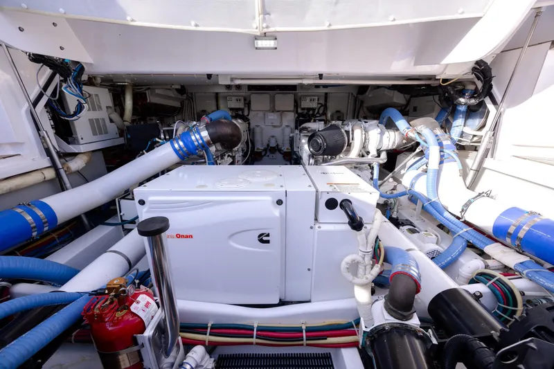 Slide: The Image of Engine room of 2015 Jarrett Bay Hardtop Express Sportfish with Onan generator and blue hoses. - 109