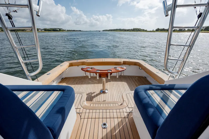 Slide: The Image of 2015 Jarrett Bay Hardtop Express Sportfish boat deck with seating, overlooking calm waters. - 15