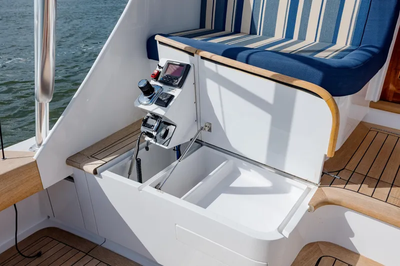 Slide: The Image of 2015 Jarrett Bay Hardtop Express Sportfish helm station with striped seating and control panel. - 18