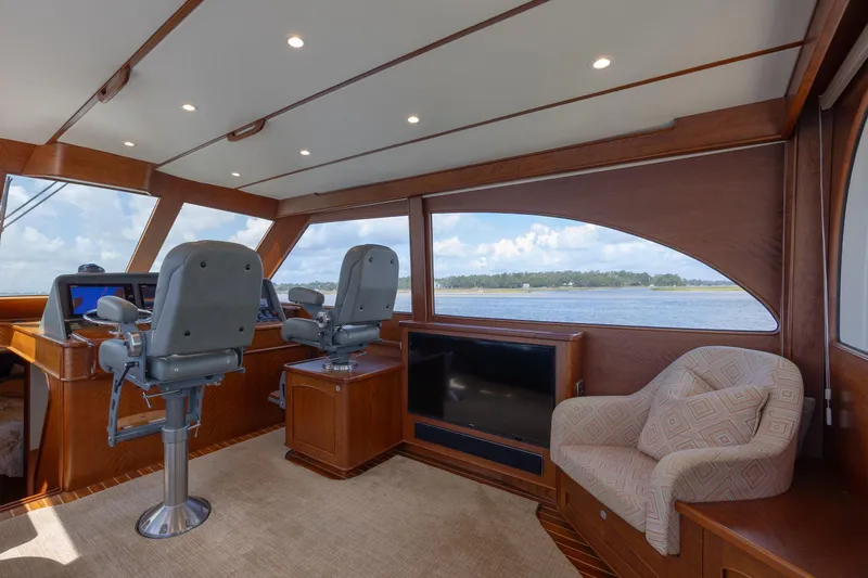 Slide: The Image of 2015 Jarrett Bay Hardtop Express Sportfish interior with helm chairs and scenic window view. - 38