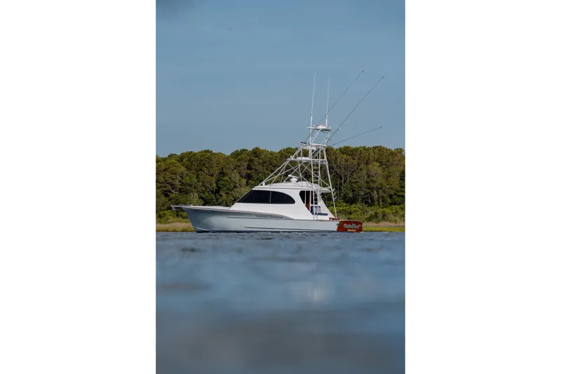 Slide: The Image of 2015 Jarrett Bay Hardtop Express Sportfish on calm water, with forested background. - 4