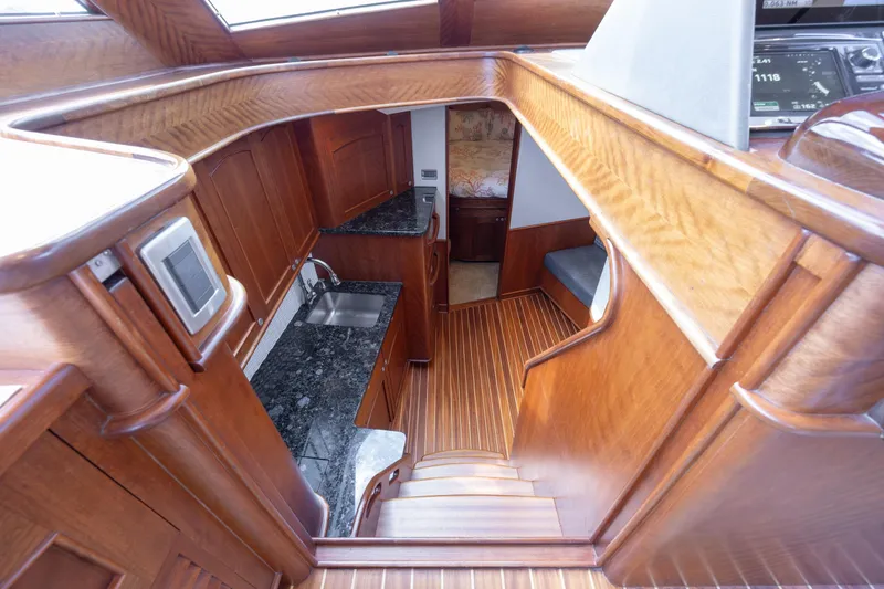 Slide: The Image of 2015 Jarrett Bay Hardtop Express Sportfish interior with wood finish and compact kitchen area. - 47