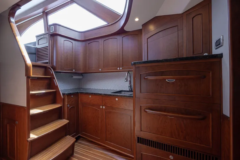 Slide: The Image of Luxurious 2015 Jarrett Bay Hardtop Express Sportfish interior with elegant wooden cabinetry and staircase. - 49