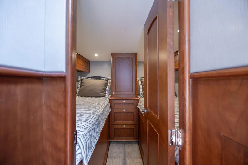 Slide: The Image of 2015 Jarrett Bay Hardtop Express Sportfish cabin with twin beds and wooden cabinetry. - 59