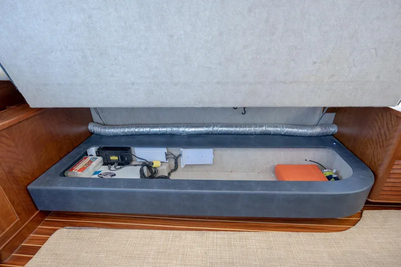 Slide: The Image of 2015 Jarrett Bay Hardtop Express Sportfish interior storage compartment with equipment and wiring. - 63
