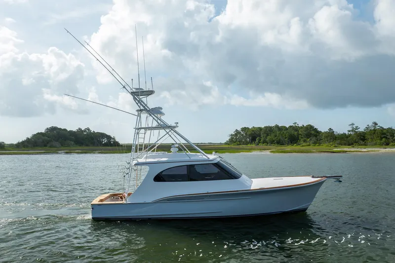 Slide: The Image of 2015 Jarrett Bay Hardtop Express Sportfish cruising on calm waters under a cloudy sky. - 74