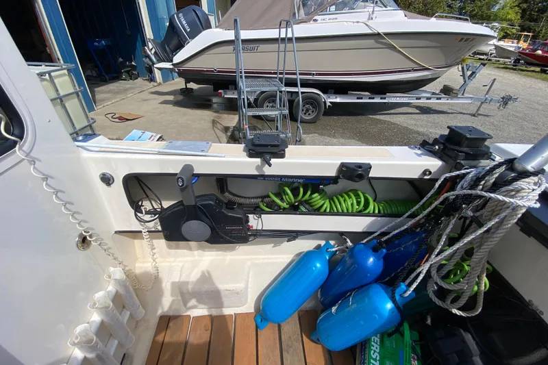 Slide: The Image of 1999 C-Dory 22' Angler boat interior with wooden flooring and marine equipment. - 12