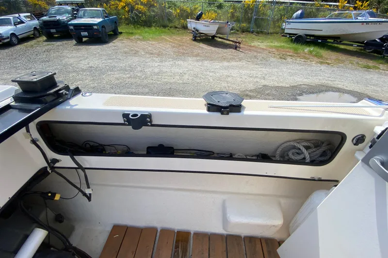 Slide: The Image of 1999 C-Dory 22' Angler boat covered on trailer, parked outdoors. - 13