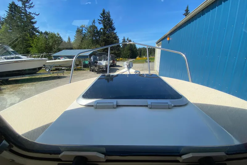 Slide: The Image of 1999 C-Dory 22' Angler boat covered and parked on a trailer in a storage area. - 14