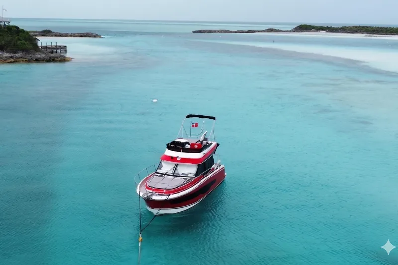 Slide: The Image of 2024 Jeanneau NC Weekender 1095 Fly in turquoise waters, anchored near a scenic coastline. - 2