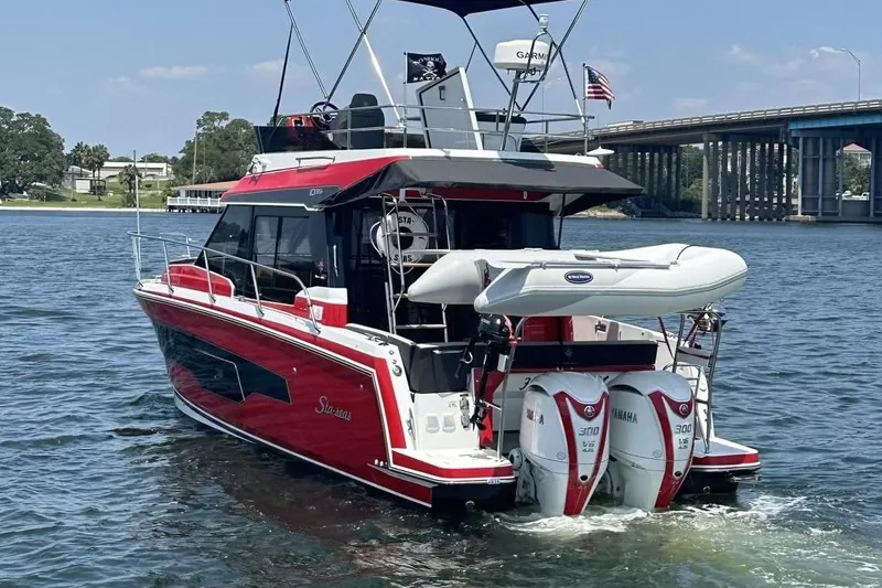 Slide: The Image of 2024 Jeanneau NC Weekender 1095 Fly cruising on a river with dual Yamaha engines. - 5