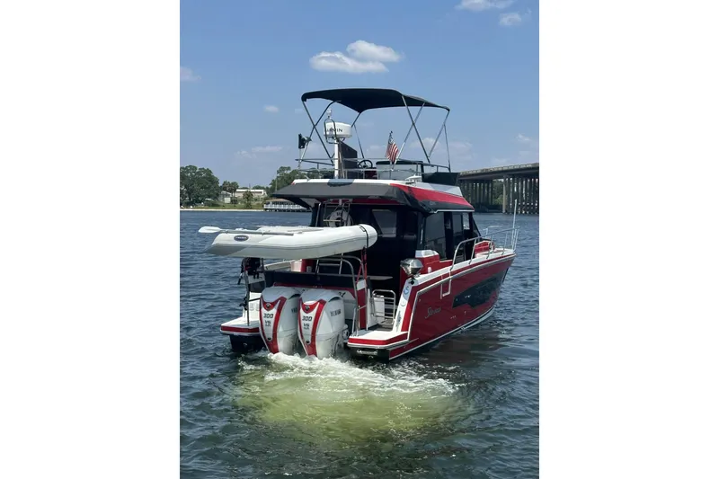 Slide: The Image of 2024 Jeanneau NC Weekender 1095 Fly boat on water, rear view with dual engines. - 7