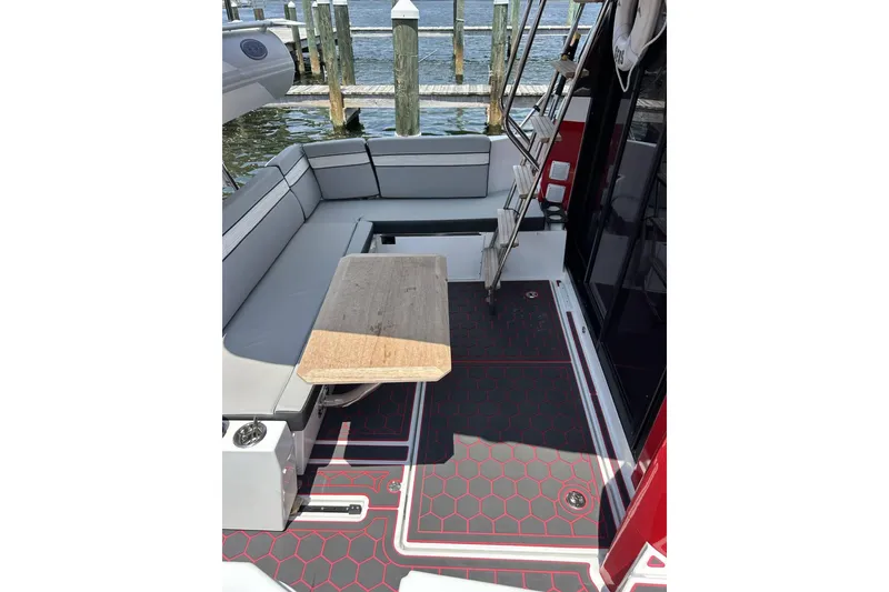 Slide: The Image of 2024 Jeanneau NC Weekender 1095 Fly cockpit with seating, table, and dock view. - 8