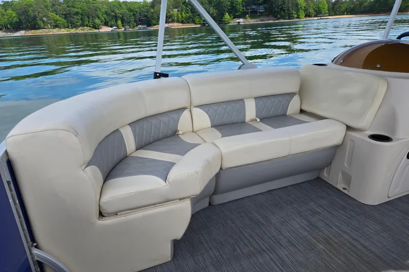 Slide: The Image of Luxurious seating on a 2022 Lexington 320 boat, overlooking a serene lake. - 14
