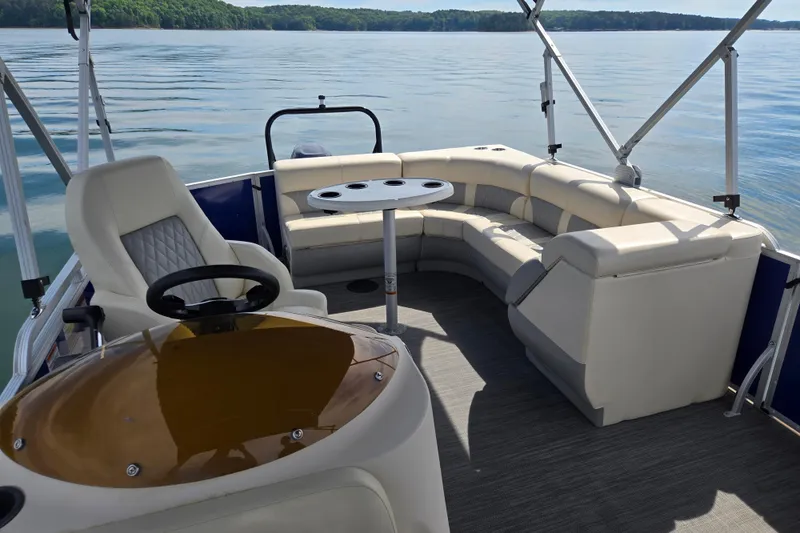 Slide: The Image of Luxurious 2022 Lexington 320 pontoon boat interior with plush seating and scenic lake view. - 15