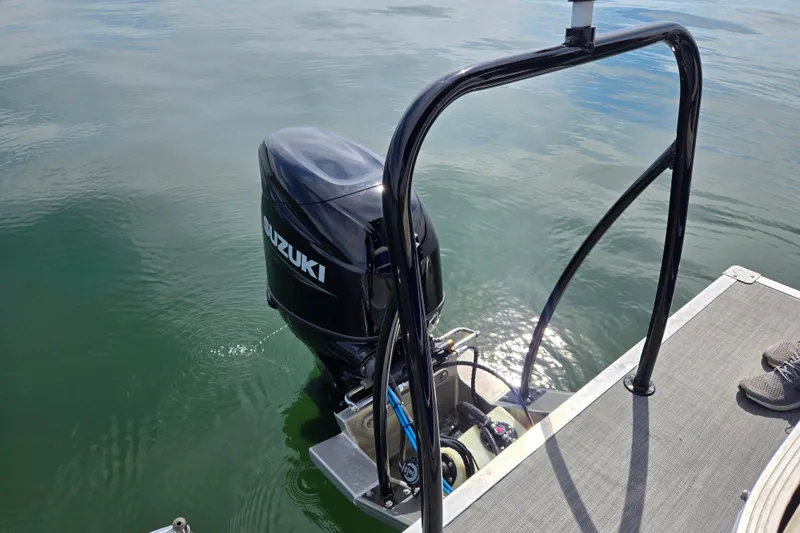Slide: The Image of Outboard motor on a 2022 Lexington 320 boat, floating on calm water. - 17
