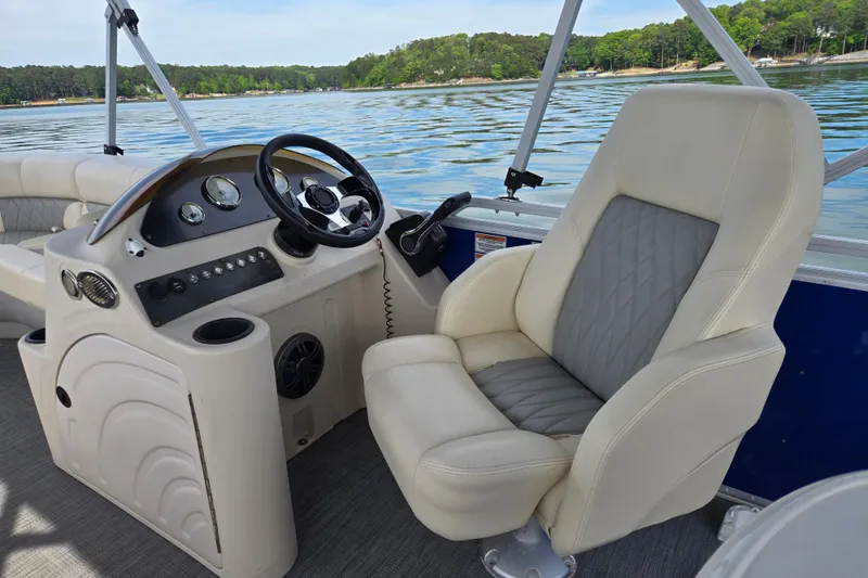 Slide: The Image of Captain's seat and helm of 2022 Lexington 320 boat on a serene lake. - 18