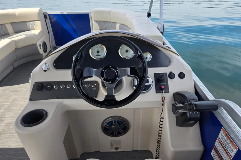 Slide: The Image of Steering console of a 2022 Lexington 320 boat with gauges and controls on a calm lake. - 19