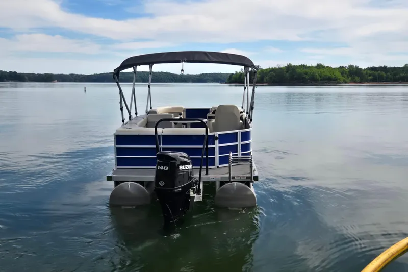Slide: The Image of 2022 Lexington 320 pontoon boat with Suzuki motor on a calm lake. - 9