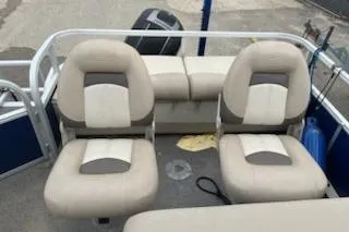Slide: The Image of 2016 Sun Tracker Fishin' Barge 24 XP3 interior with beige seating and boat motor. - 2