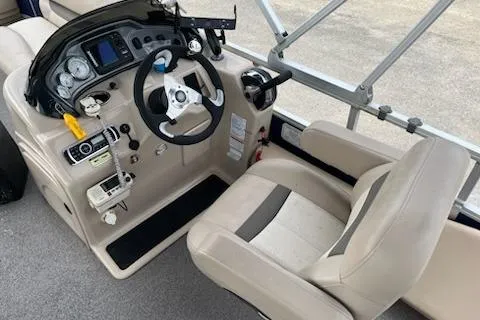 Slide: The Image of 2016 Sun Tracker Fishin' Barge 24 XP3 boat cockpit with steering wheel and controls. - 5