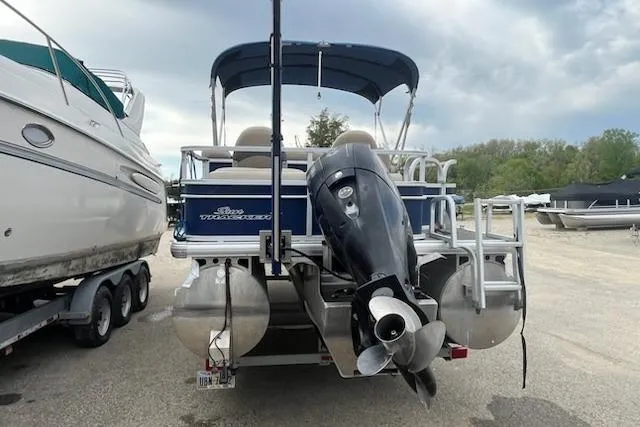 Slide: The Image of 2016 Sun Tracker Fishin' Barge 24 XP3 pontoon boat with outboard motor, docked outdoors. - 7