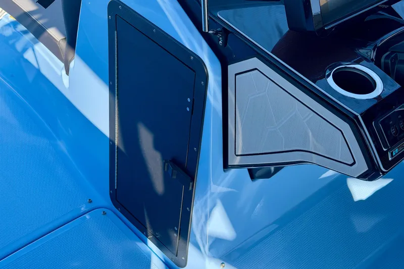 Slide: The Image of 2025 Yamaha Boats 255XD interior storage compartment with open door, showcasing sleek design. - 11