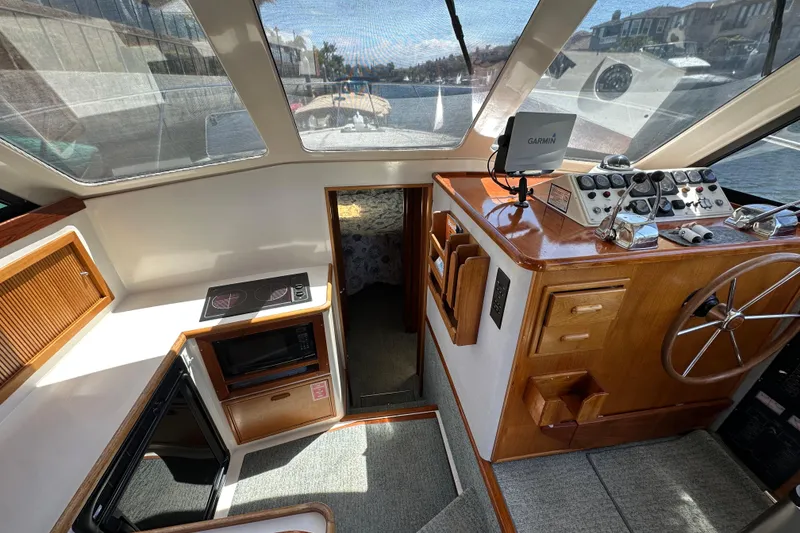 Slide: The Image of Interior of 1999 Riviera 3600 Sport Yacht with helm, kitchen, and navigation equipment. - 10