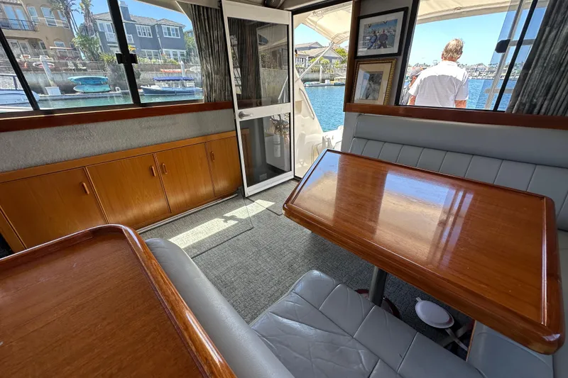 Slide: The Image of Interior of 1999 Riviera 3600 Sport Yacht with wooden table and waterfront view. - 15