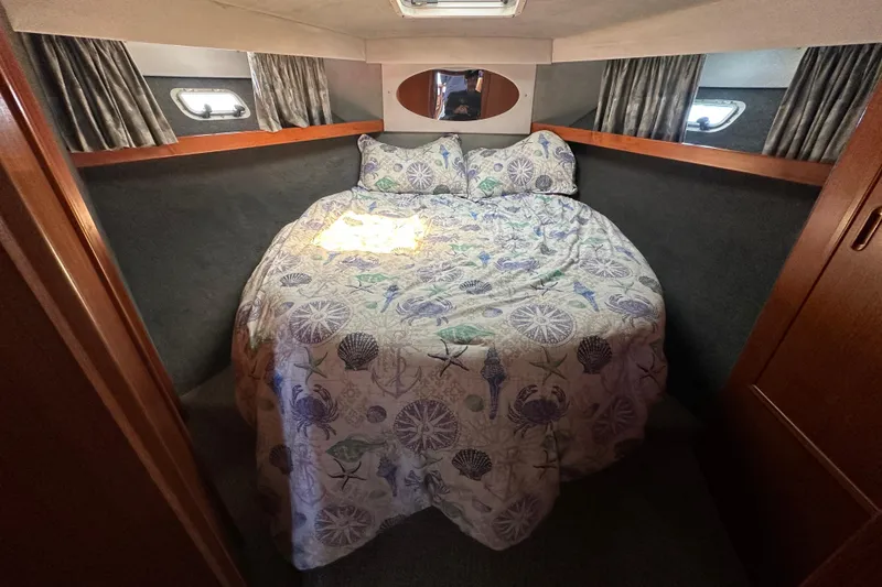 Slide: The Image of Cozy bedroom in 1999 Riviera 3600 Sport Yacht with nautical-themed bedding. - 16