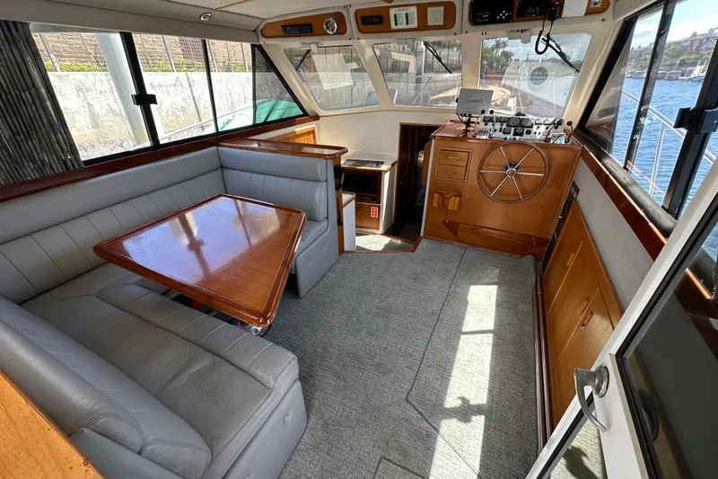 Slide: The Image of Interior of 1999 Riviera 3600 Sport Yacht with helm, seating, and wooden table. - 5