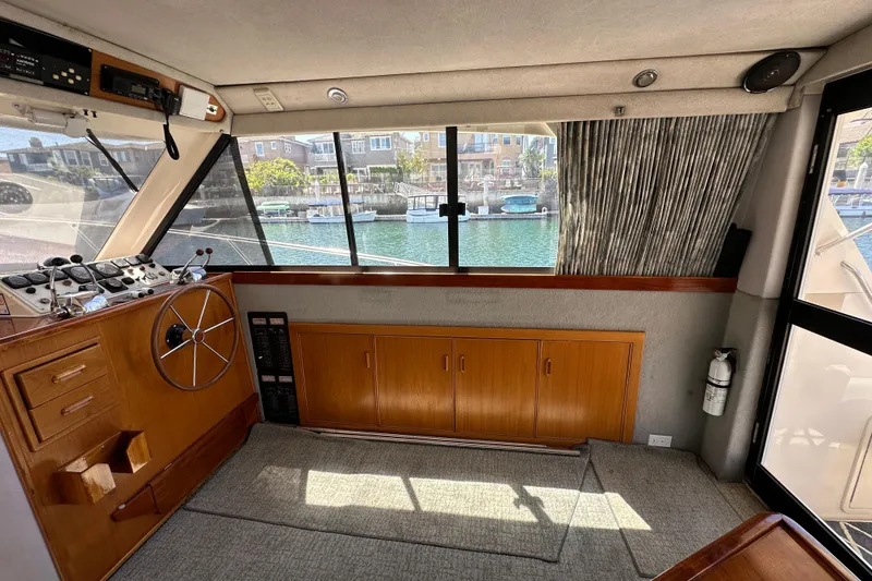 Slide: The Image of Interior of 1999 Riviera 3600 Sport Yacht with helm, wooden cabinetry, and waterfront view. - 6