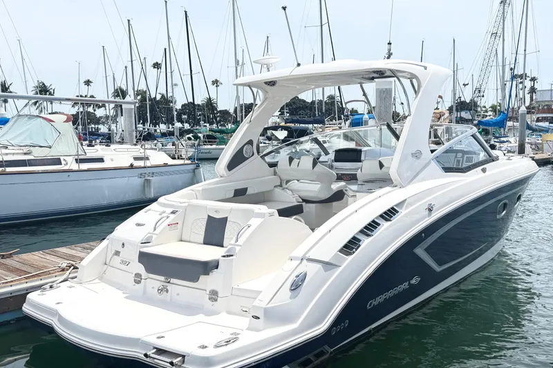 The Image of 2014 Chaparral 327 SSX boat docked at a marina with sailboats in the background. - 0