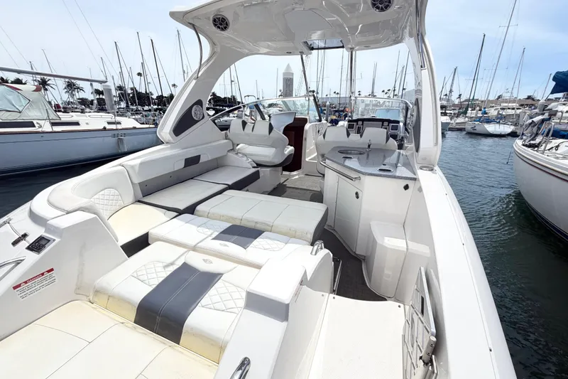 Slide: The Image of 2014 Chaparral 327 SSX boat interior with seating and kitchenette, docked at marina. - 14