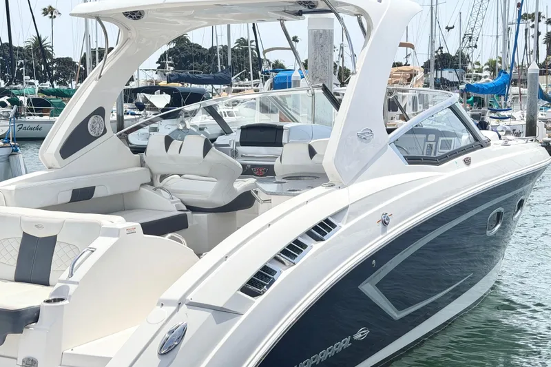Slide: The Image of 2014 Chaparral 327 SSX boat docked in a marina, featuring sleek design and luxurious seating. - 2