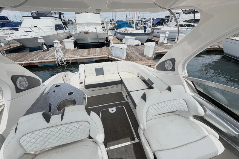 Slide: The Image of 2014 Chaparral 327 SSX boat interior with luxurious seating at a marina dock. - 25