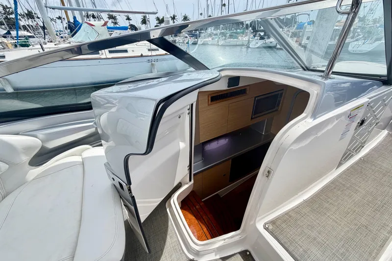 Slide: The Image of 2014 Chaparral 327 SSX boat interior with open cabin door, docked at marina. - 26