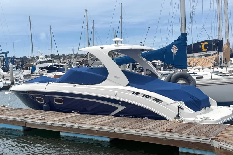 Slide: The Image of 2014 Chaparral 327 SSX boat docked at marina with blue covers. - 3