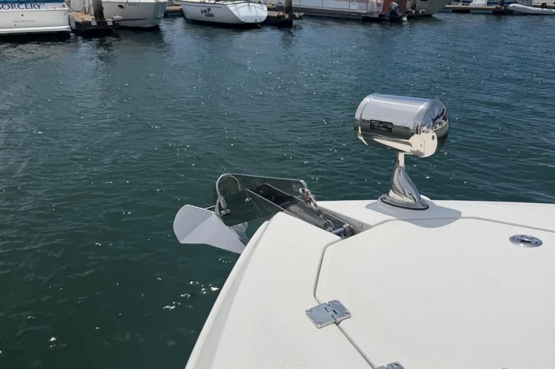 Slide: The Image of 2014 Chaparral 327 SSX boat docked, featuring anchor and spotlight on calm water. - 39