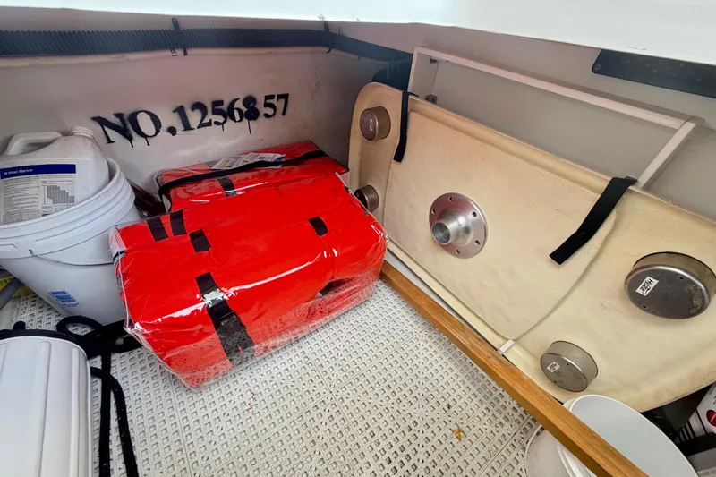 Slide: The Image of Storage compartment in a 2014 Chaparral 327 SSX boat with safety equipment and supplies. - 42