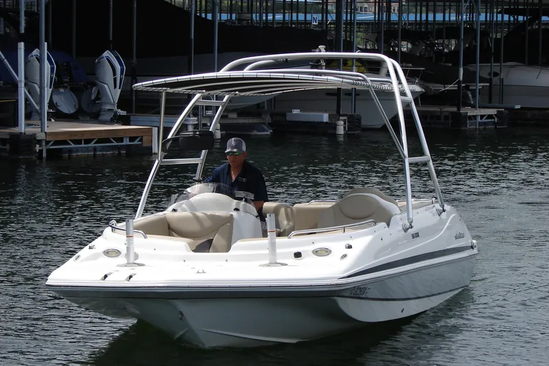 Slide: The Image of 2017 Hurricane SunDeck Sport 202 IO boat on water near dock. - 10