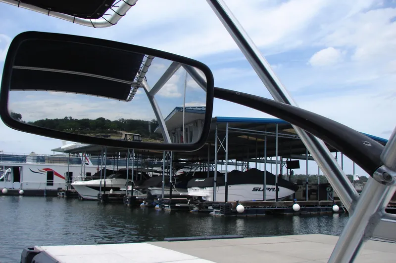 Slide: The Image of 2017 Hurricane SunDeck Sport 202 IO boat docked at marina, reflected in rearview mirror. - 18