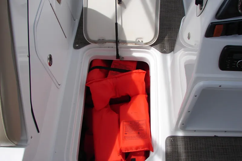 Slide: The Image of Storage compartment with orange life jackets on a 2017 Hurricane SunDeck Sport 202 IO boat. - 29
