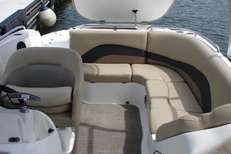 Slide: The Image of 2017 Hurricane SunDeck Sport 202 IO boat interior with beige seating and helm near water. - 36