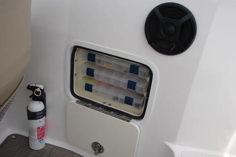 Slide: The Image of 2017 Hurricane SunDeck Sport 202 IO storage compartment with tackle boxes, speaker, and fire extinguisher. - 39