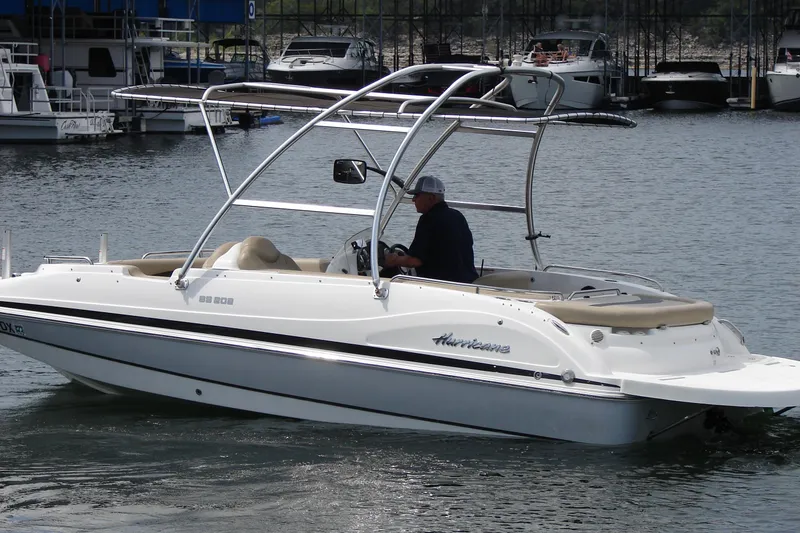 Slide: The Image of 2017 Hurricane SunDeck Sport 202 IO boat cruising on a calm lake near a marina. - 4