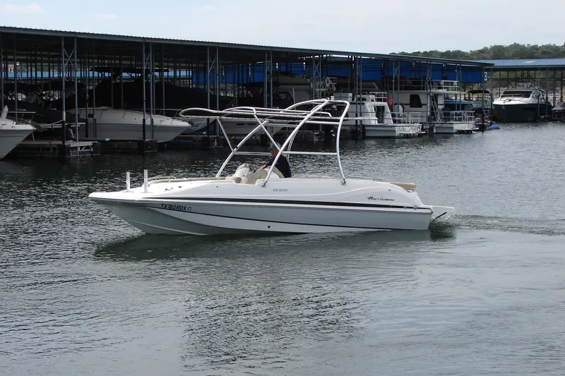 Slide: The Image of 2017 Hurricane SunDeck Sport 202 IO boat cruising near a marina. - 5