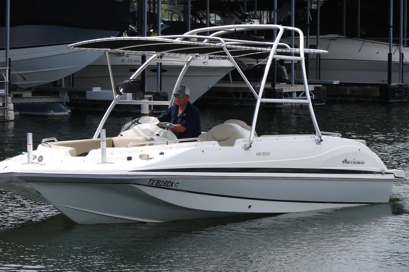 Slide: The Image of 2017 Hurricane SunDeck Sport 202 IO boat on water, featuring sleek design and canopy. - 6